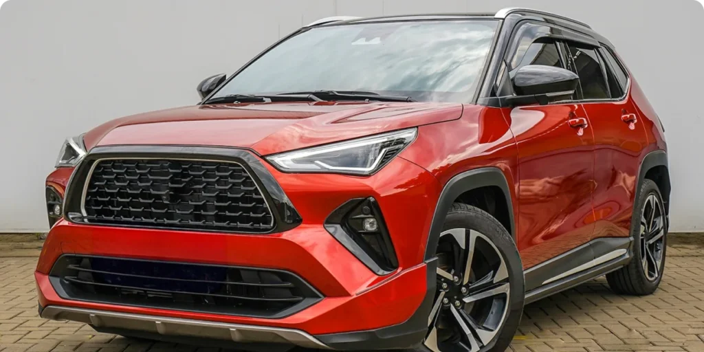 A front three-quarter view of a bright red compact Asian SUV, possibly a Toyota RAV4.