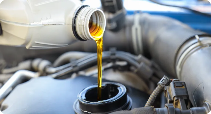 A close-up of fresh, golden oil being poured into a car engine, highlighting oil change service.