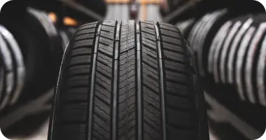 A close-up view of a tire tread pattern and sidewall, representing tire sales and replacement.